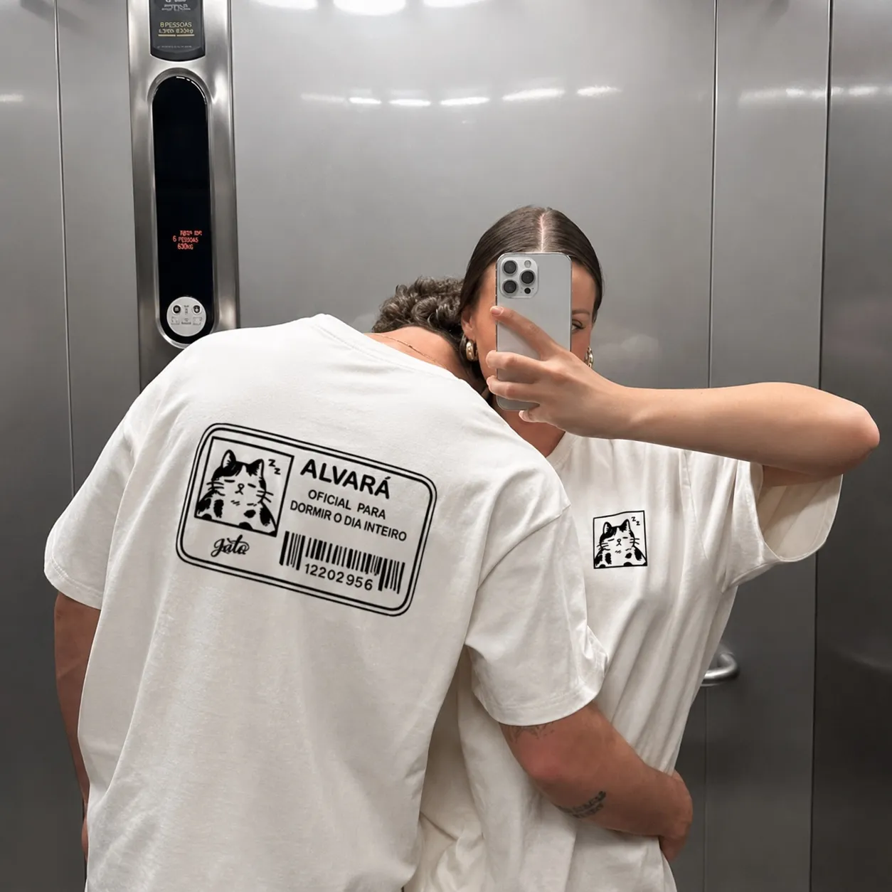 Casal com camisetas JULU brancas mostrando a estampa ALVARÁ de design autoral